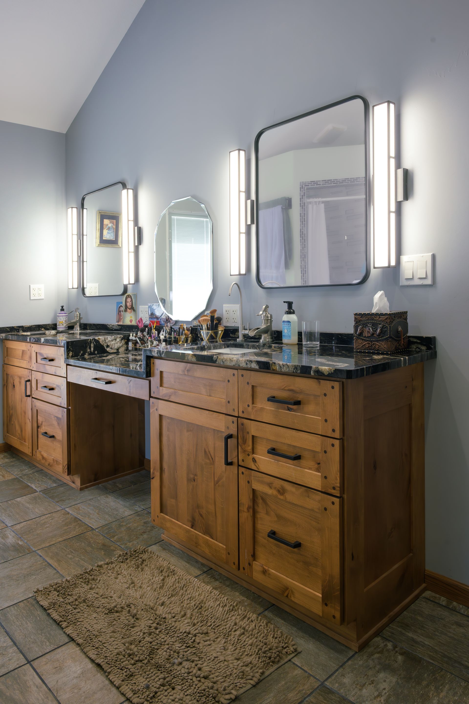 Custom stained wood bathroom vanity and makeup station with wood plugs in corners of doors.