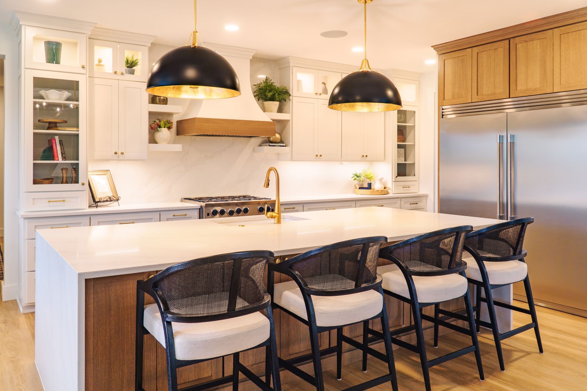 Custom, modern painted kitchen cabinets and stained wood  island with waterfall style quartz countertop and pendant lights.