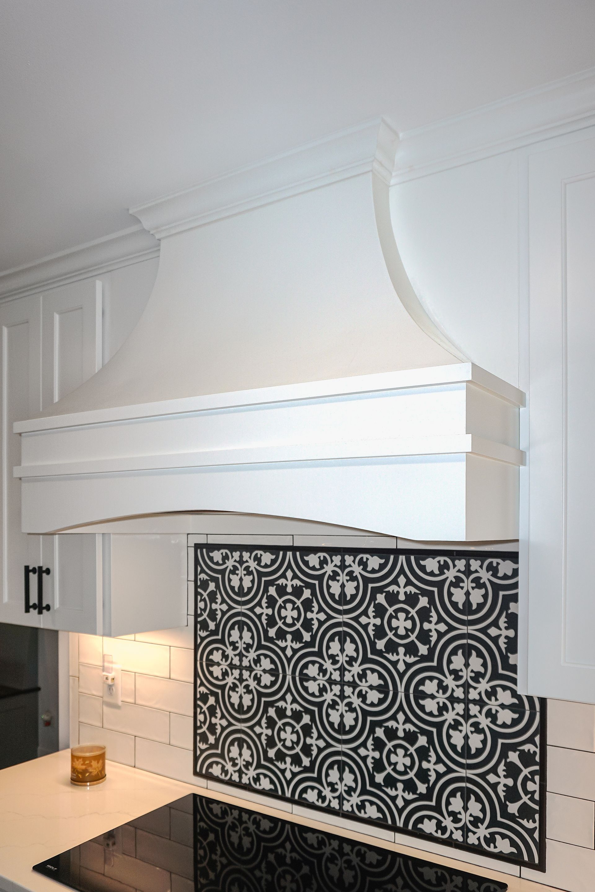 Custom white painted wood curved range hood.