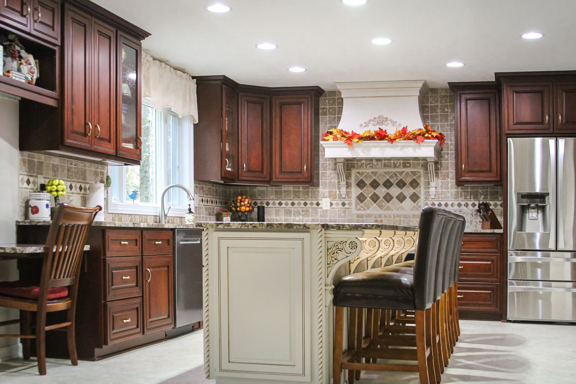 Custom traditional stained wood kitchen cabinets with fancy carvings in island.