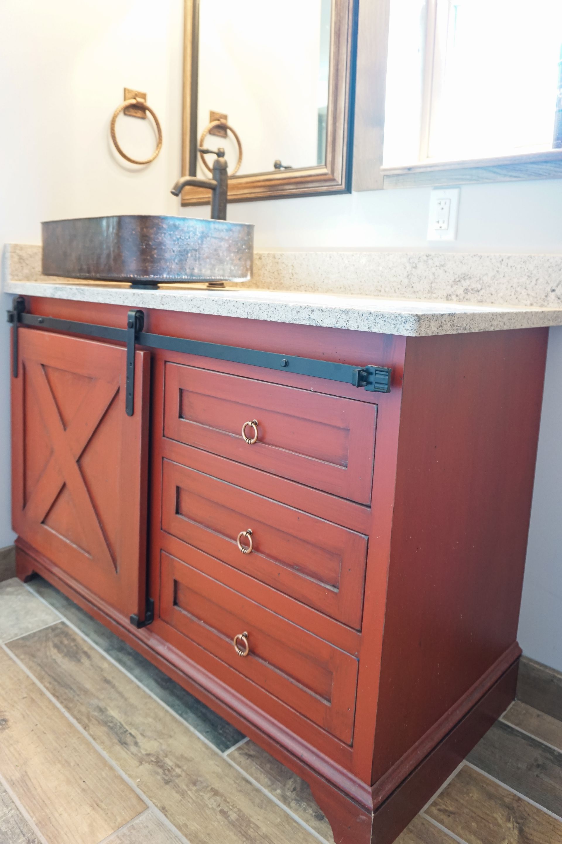 Custom red painted and glazed wood bathroom vanity with sliding barn doors.
