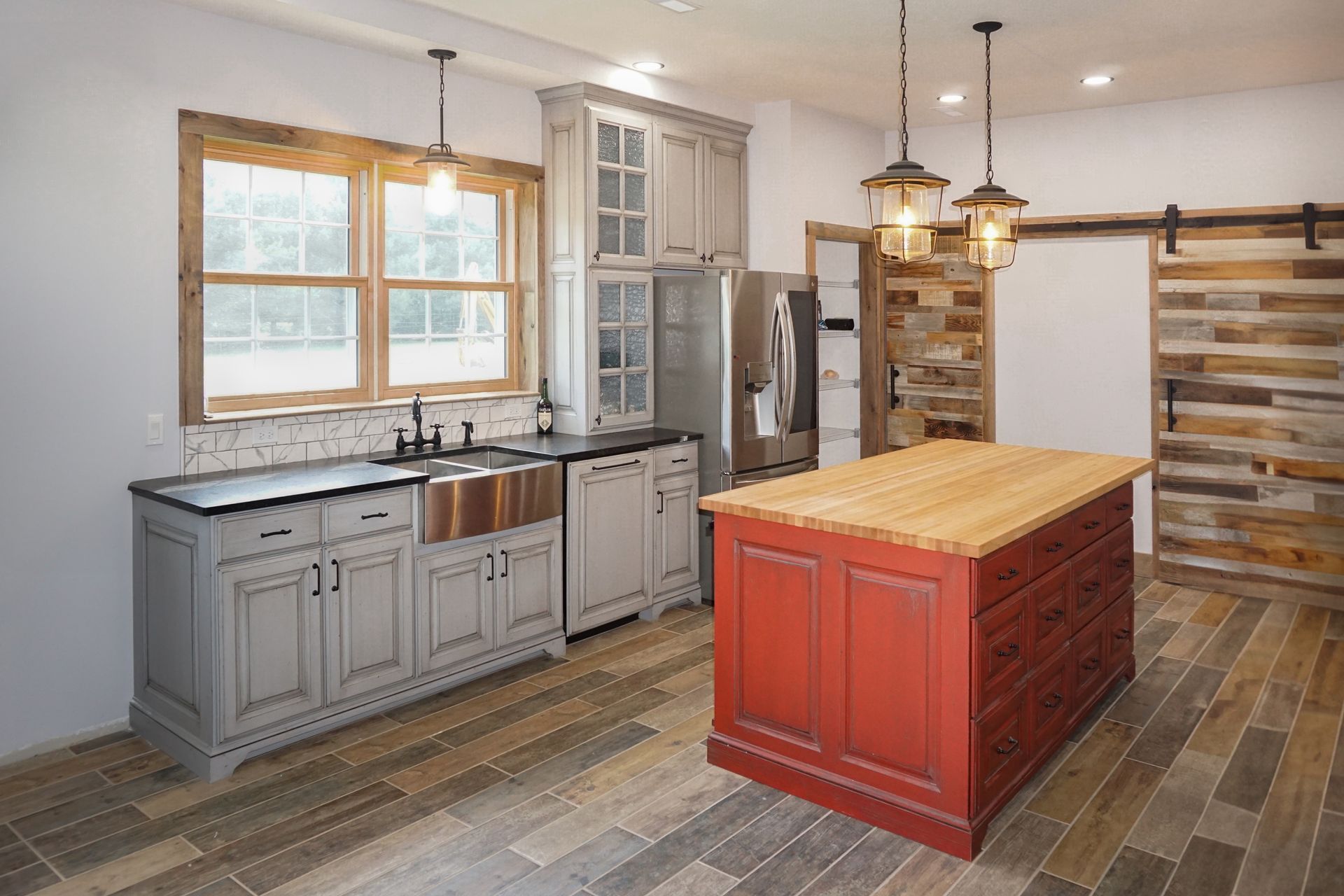 Custom gray painted and glazed kitchen cabinets with red painted and glazed island.