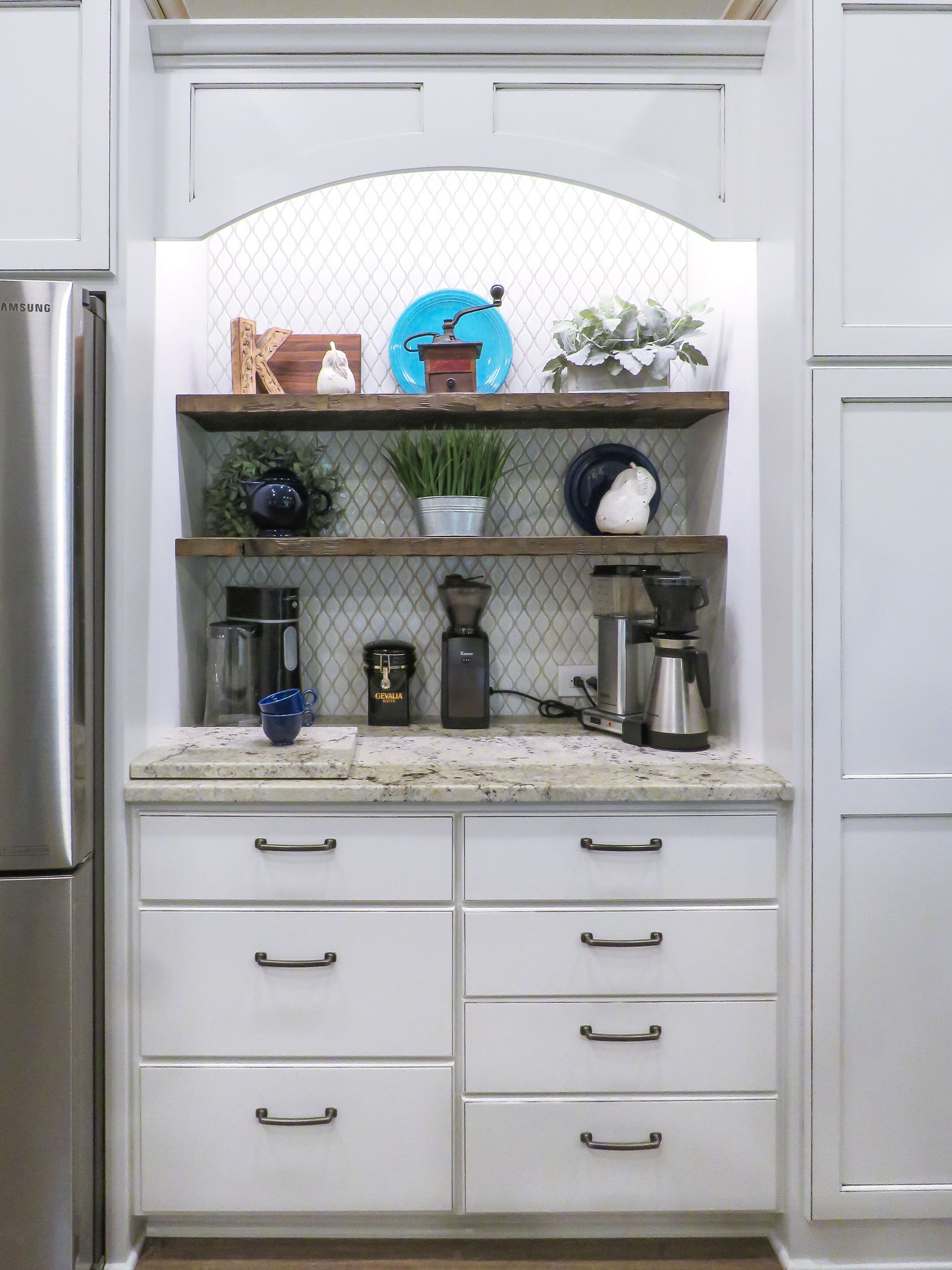 Custom white painted wood beverage center with arched opening.