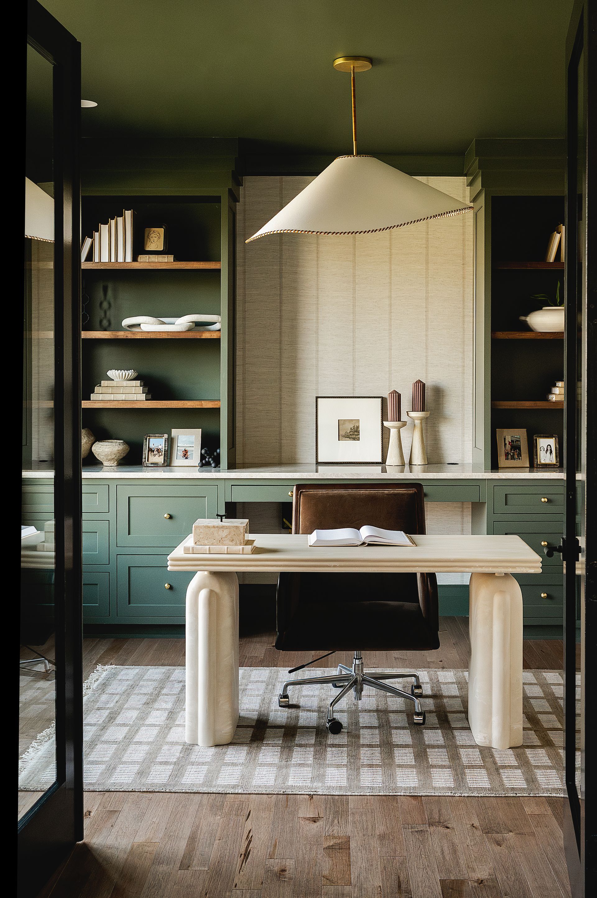 Custom green painted wood office storage solution with floating stained wood shelves.
