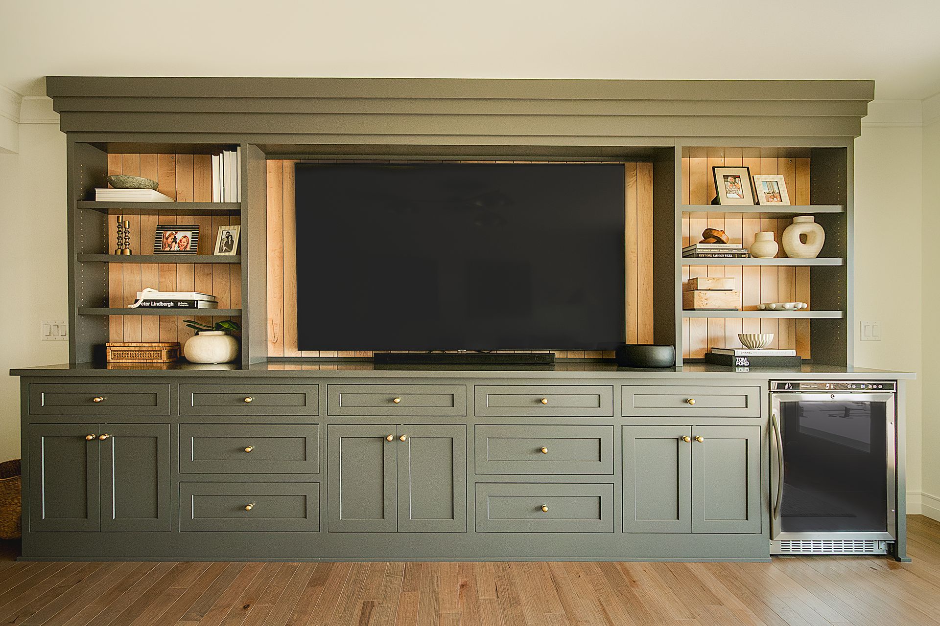 Custom green painted wood entertainment center with stained wood back and inset doors and drawers.