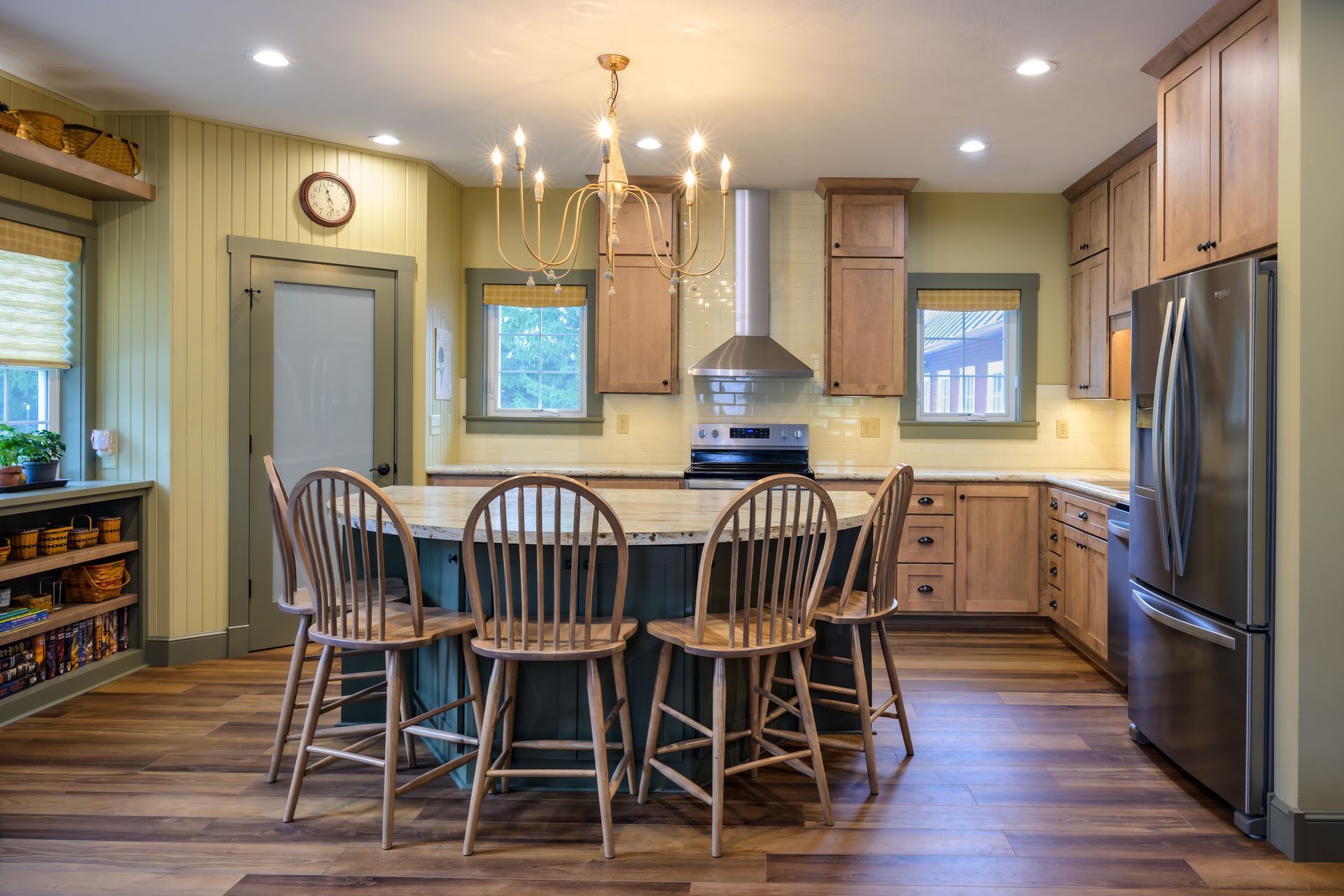 Custom, stained modern wood  kitchen cabinets and island, stainless appliances and range hood.