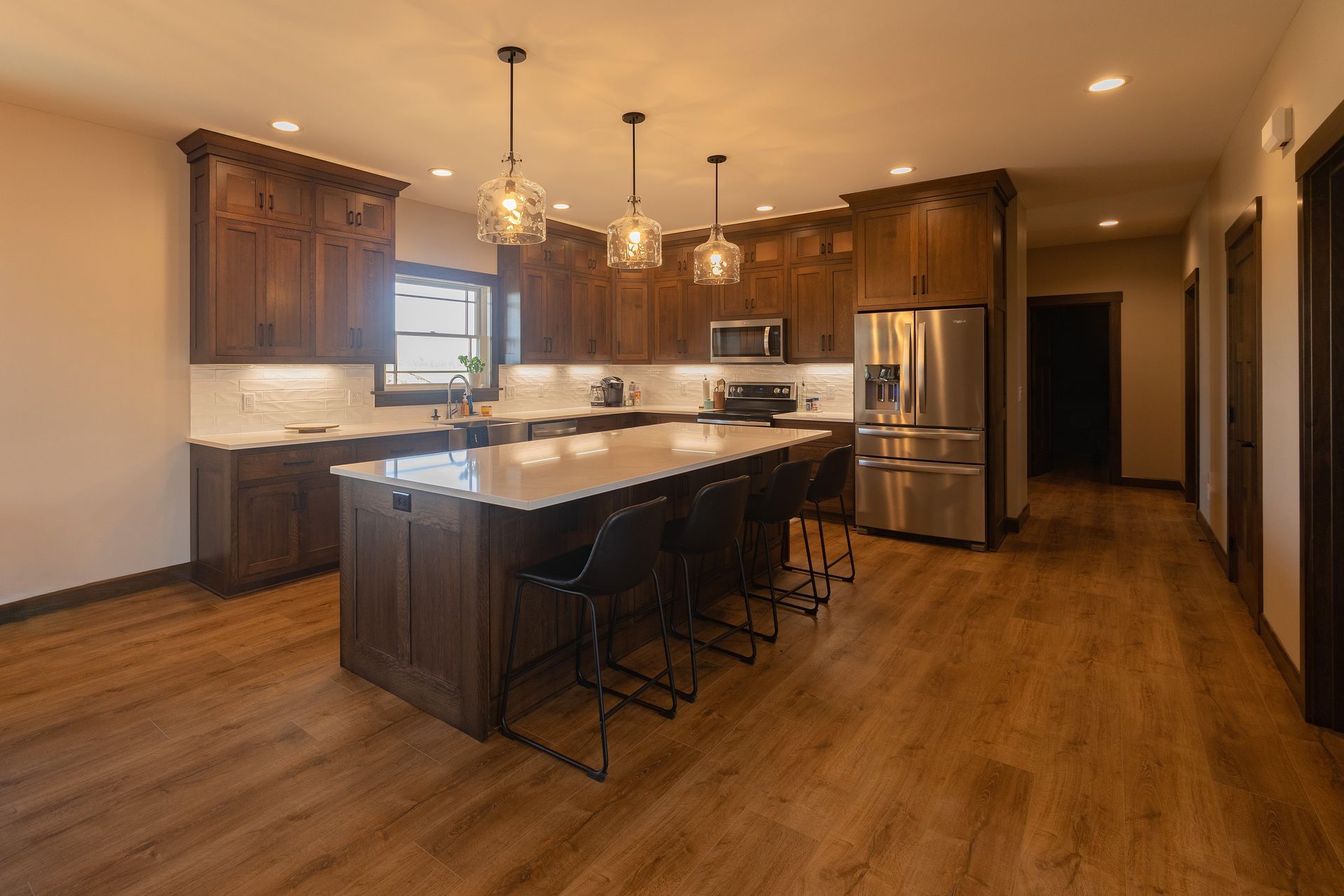 Custom stained hickory kitchen cabinets and island with lovely pendant lights.