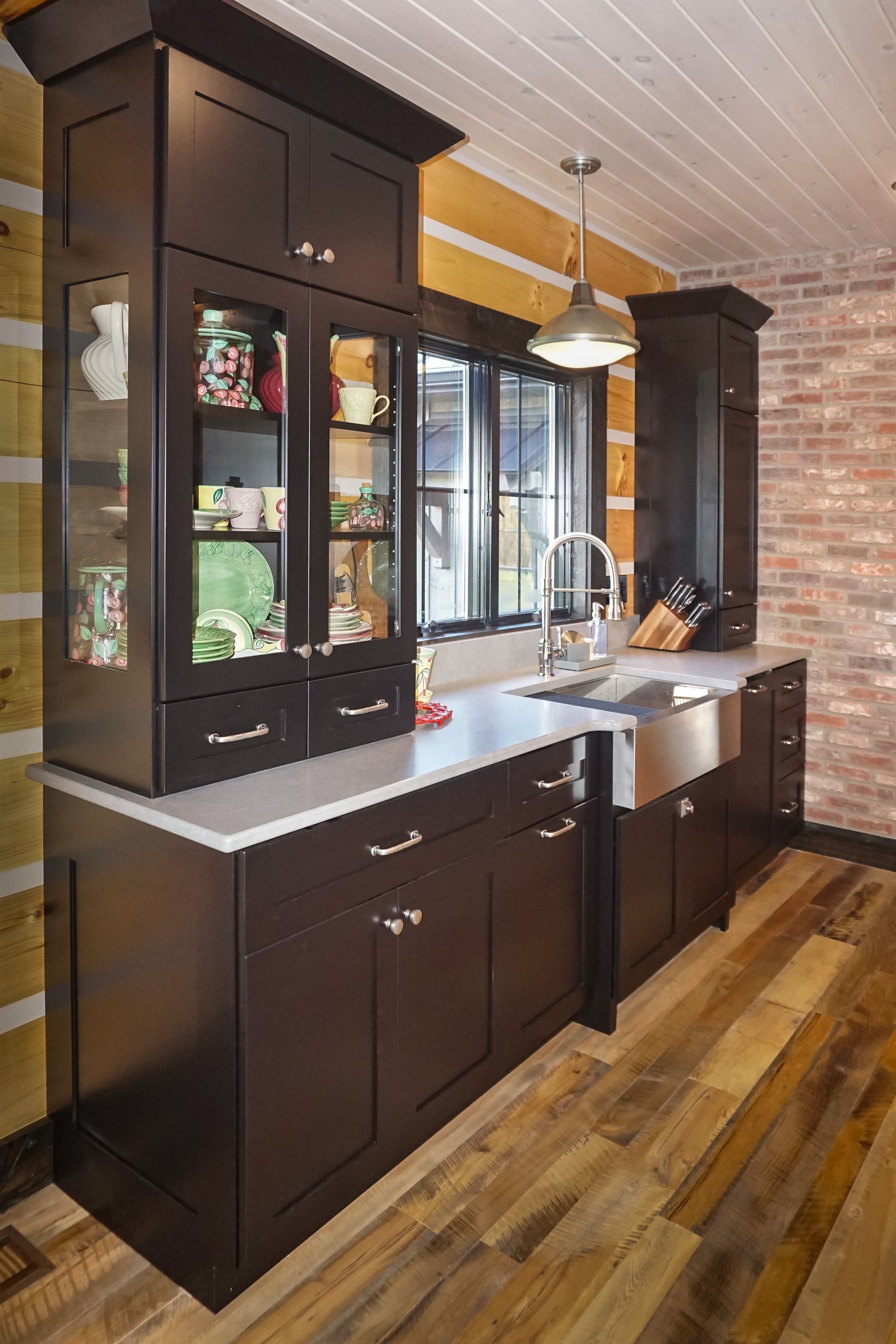 Custom dark stained wood kitchen cabinets with stainless farm house sink.