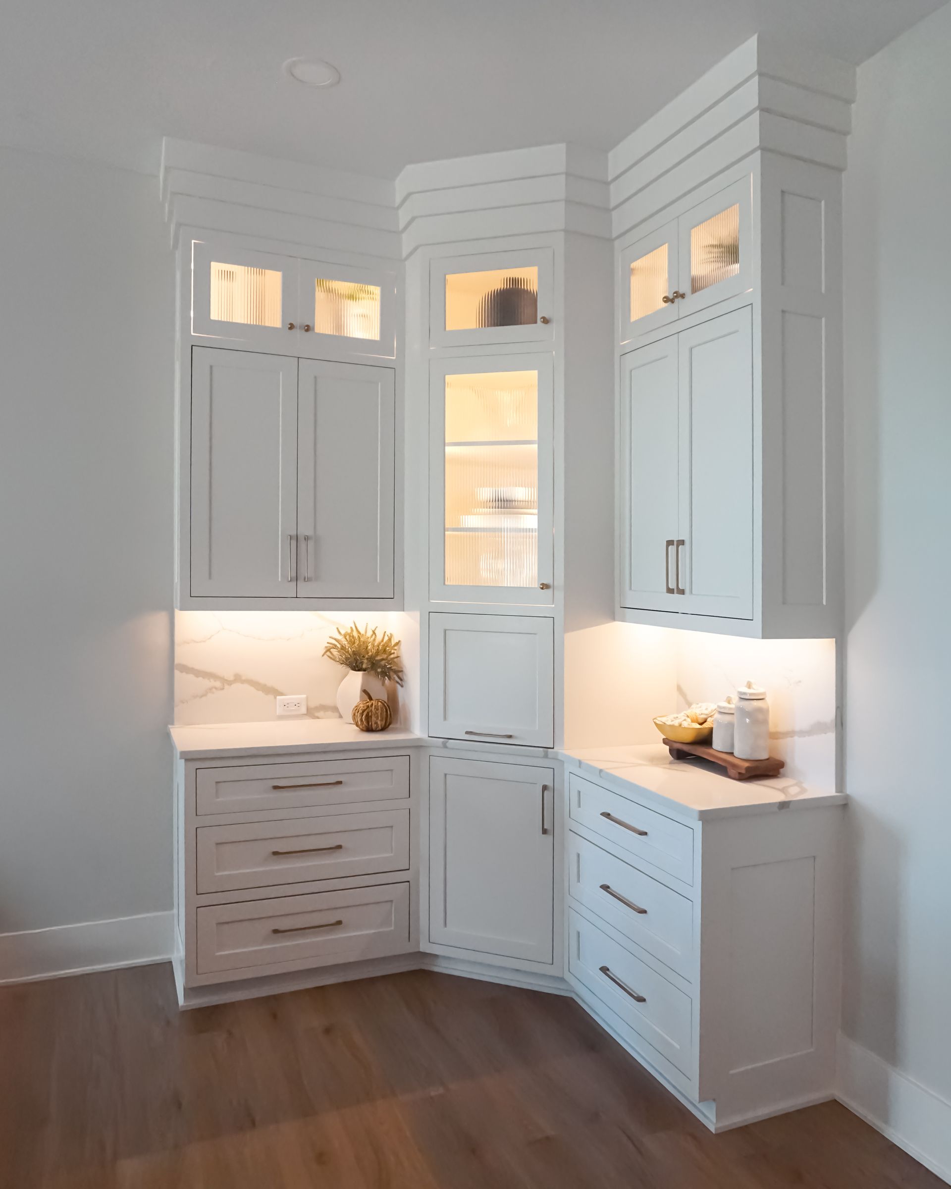 Custom white painted wood full height kitchen cabinets with appliance garage and glass front.