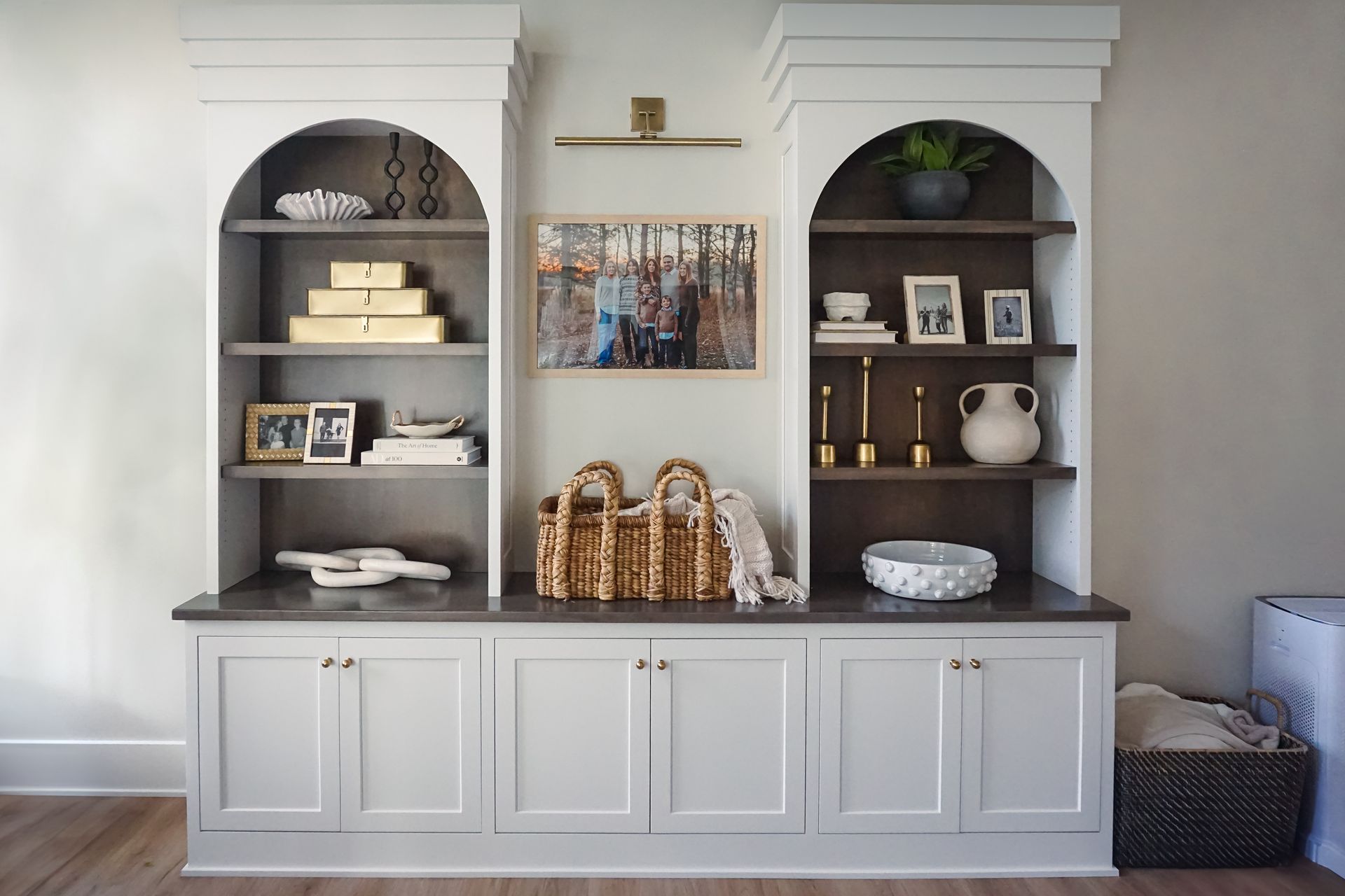 Custom white painted wood curio cabinet with unique arched openings.