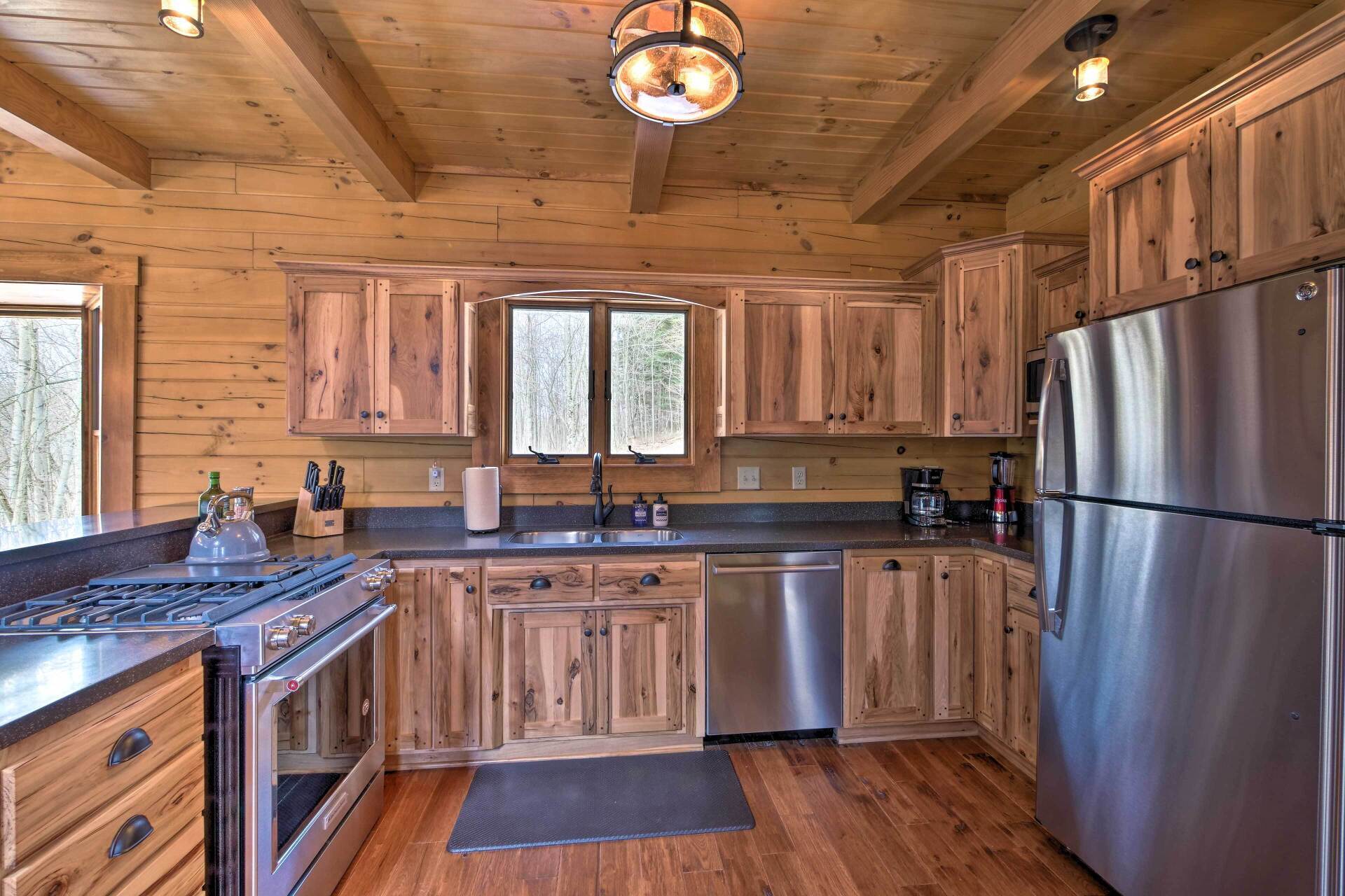 Custom clear stained hickory kitchen cabinets with walnut plugs in corners in a log home.