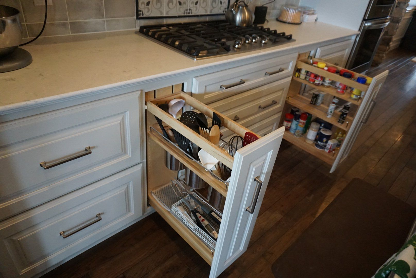 Custom white painted wood cabinet with utensil organizer tower.