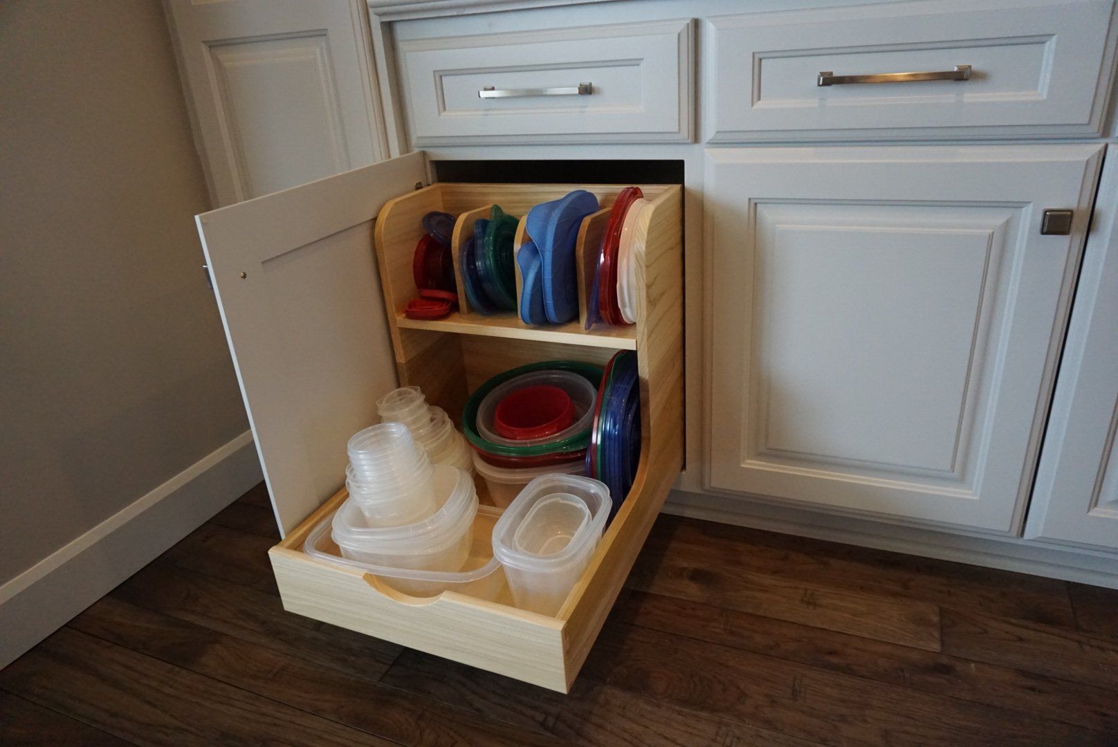Custom white painted wood kitchen cabinet with two tier organizer.