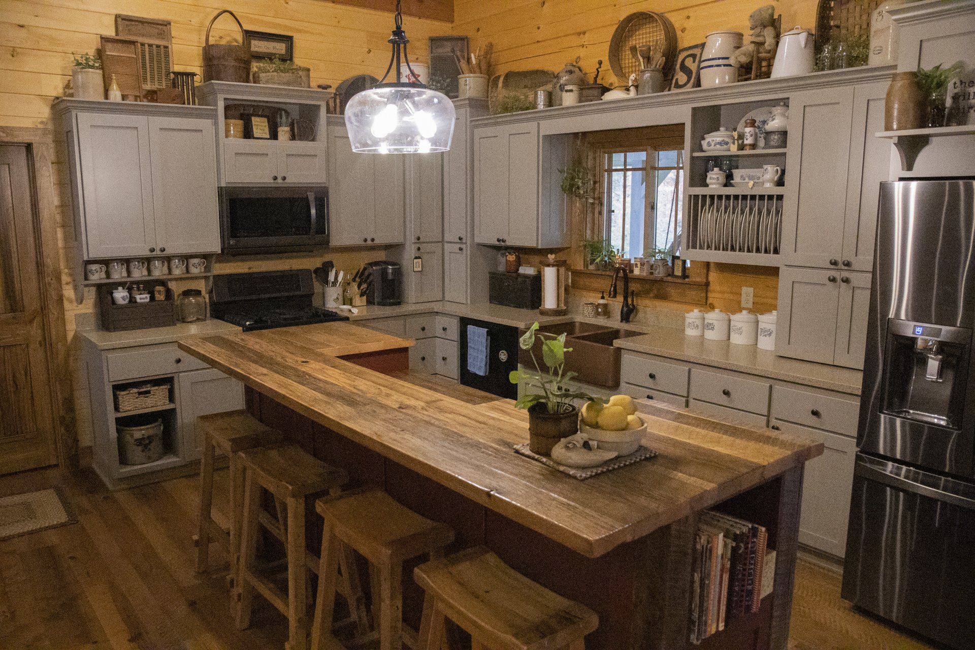 Custom gray painted wood kitchen cabinets with rustic rough sawn wood island.