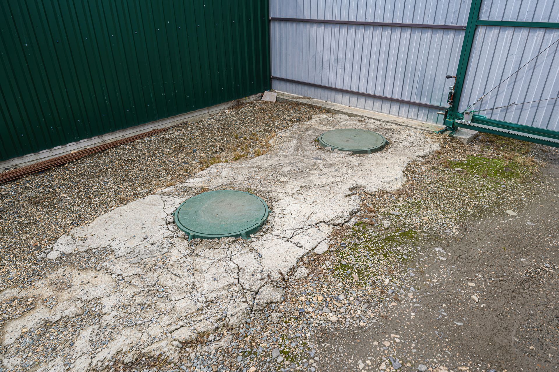Septic tank access lids on a cracked concrete pad needing septic tank repair Septic tank access lids on a cracked concrete pad needing septic tank repair