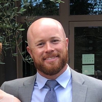 A man with a beard and mustache is smiling for the camera.