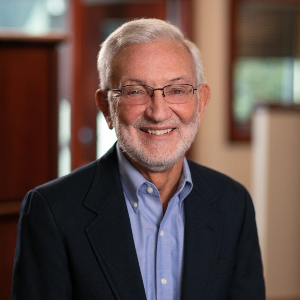 A man with glasses and a beard is smiling for the camera.