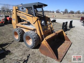 A small tractor with a large bucket is sitting in the dirt ..