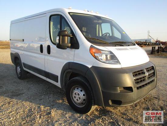 A white van is parked in a dirt field.