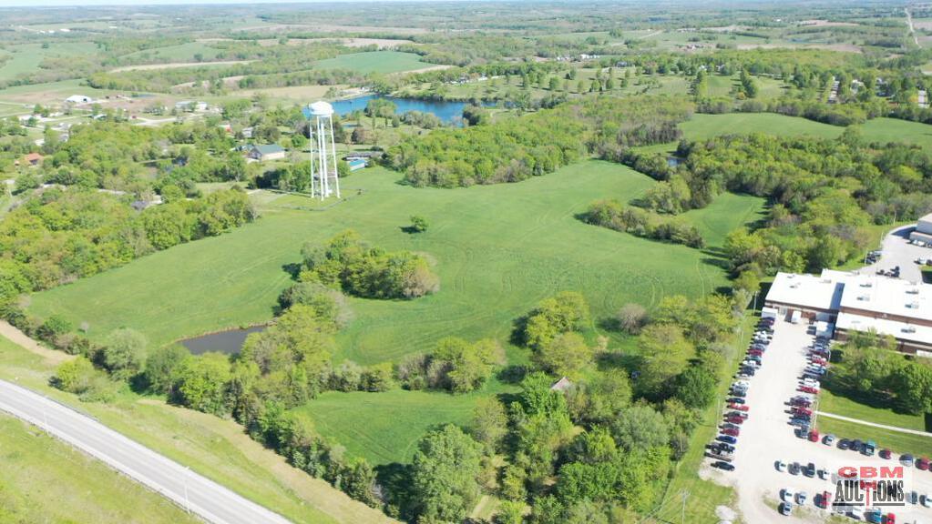 An aerial view of a large green field with a water tower in the background