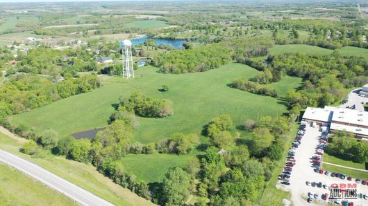 An aerial view of a large green field with a water tower in the background
