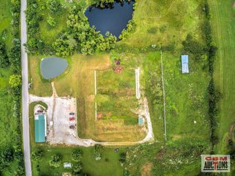 An aerial view of a farm with a pond in the middle of it.