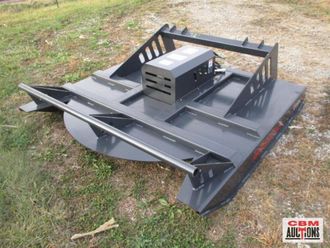 A lawn mower is sitting in the grass at a gdm auction