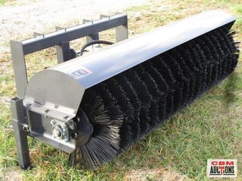 A broom is sitting in the grass with the word auction on it