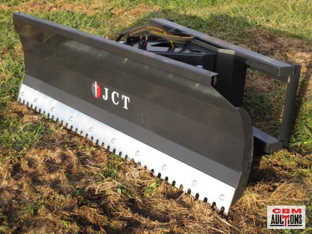 A jct snow plow is sitting in the grass