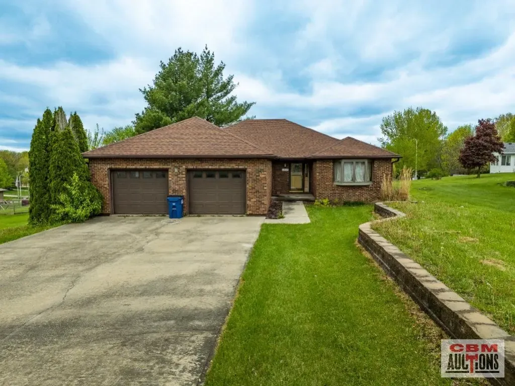 A brick house with two garage doors is for sale by odm auctions