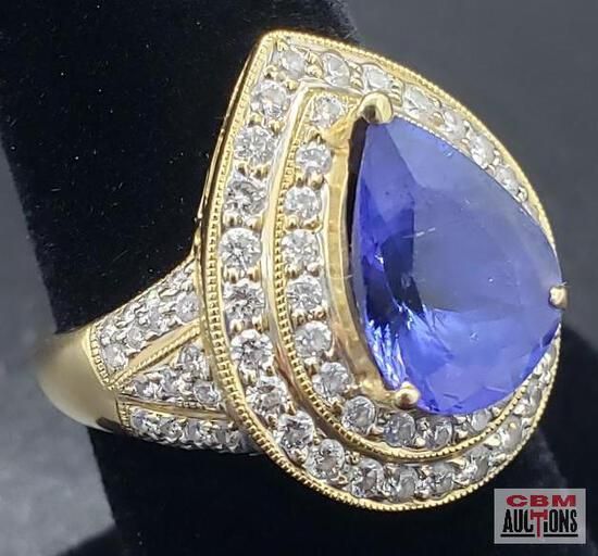 A yellow gold ring with a blue stone and diamonds
