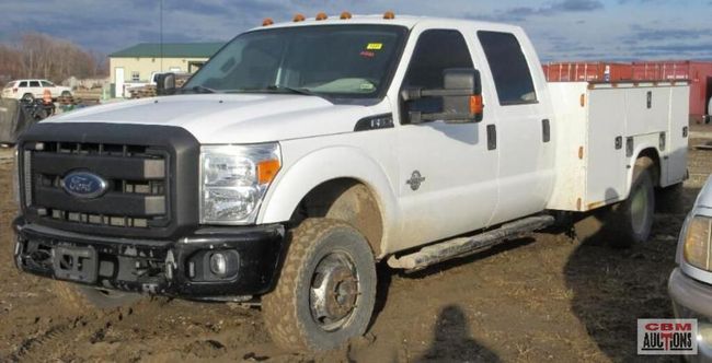 A white ford truck is parked in the dirt