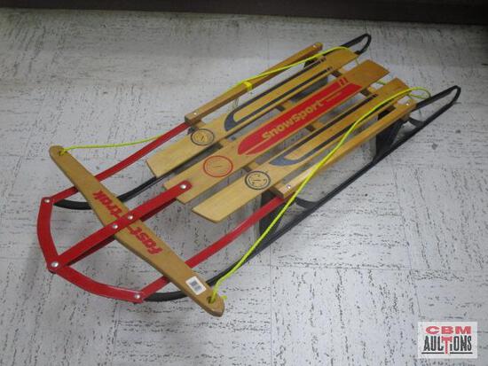 A wooden sled is sitting on a concrete floor