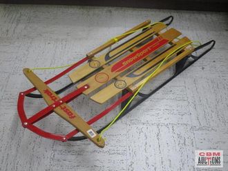 A wooden sled is sitting on a concrete floor