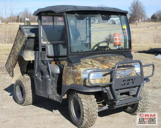 A camouflage utility vehicle is parked in a field