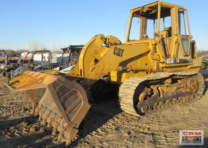 A yellow cat bulldozer is parked in the dirt