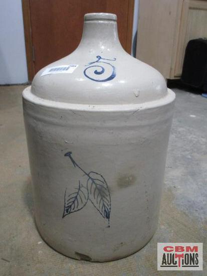 A large ceramic jar with a leaf design on it