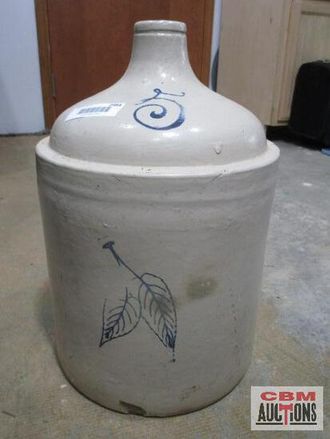 A large ceramic jar with a leaf design on it