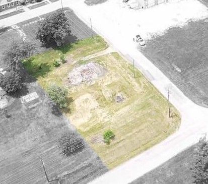 An aerial view of a residential area with a lot of grass and trees.