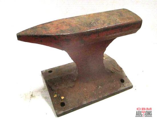 An anvil is sitting on top of a wooden base with a cbm auction logo in the corner