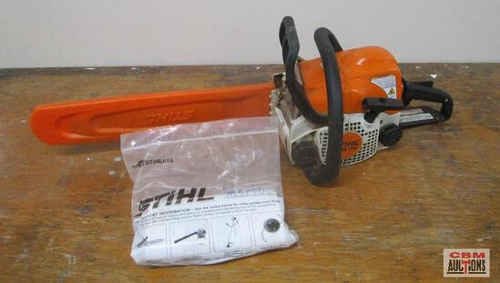 A chainsaw is sitting on a wooden table next to a bag of stihl parts.