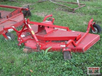 A red lawn mower is sitting in the grass