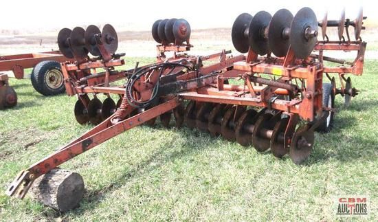 A row of tractors are parked in a grassy field.