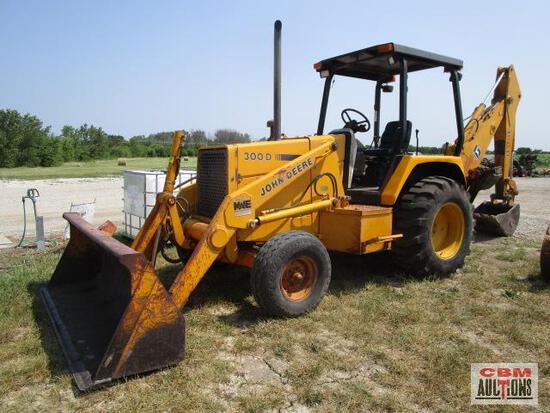 A yellow john deere backhoe is parked in a field
