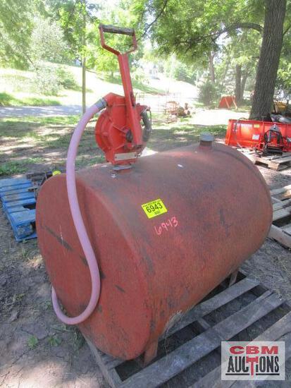 A large red tank with a pink hose attached to it is sitting on a wooden pallet.