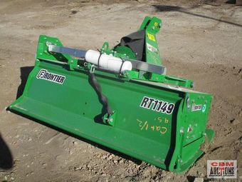 A green frontier tractor is sitting in the dirt