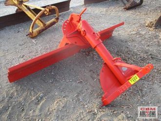 A red tractor blade with a yellow tag on it
