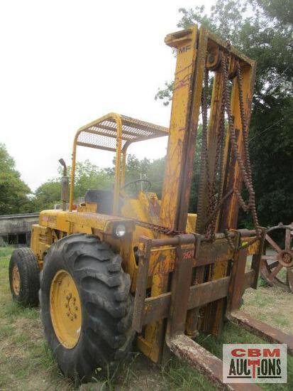A yellow forklift is sitting in the grass at a cbm auction