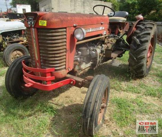 A red tractor is parked in a grassy field