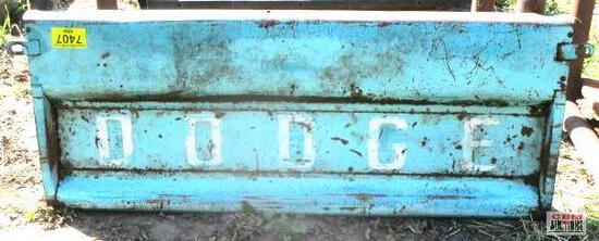 A blue dodge truck is parked in the grass.